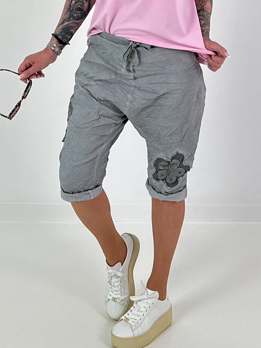 Kurze Baggy mit Häkelblumen und Pailletten - grau
