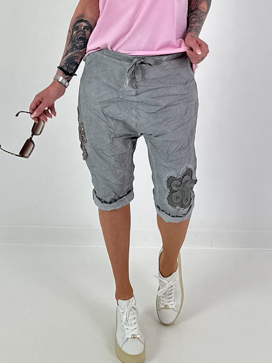 Kurze Baggy mit Häkelblumen und Pailletten - grau