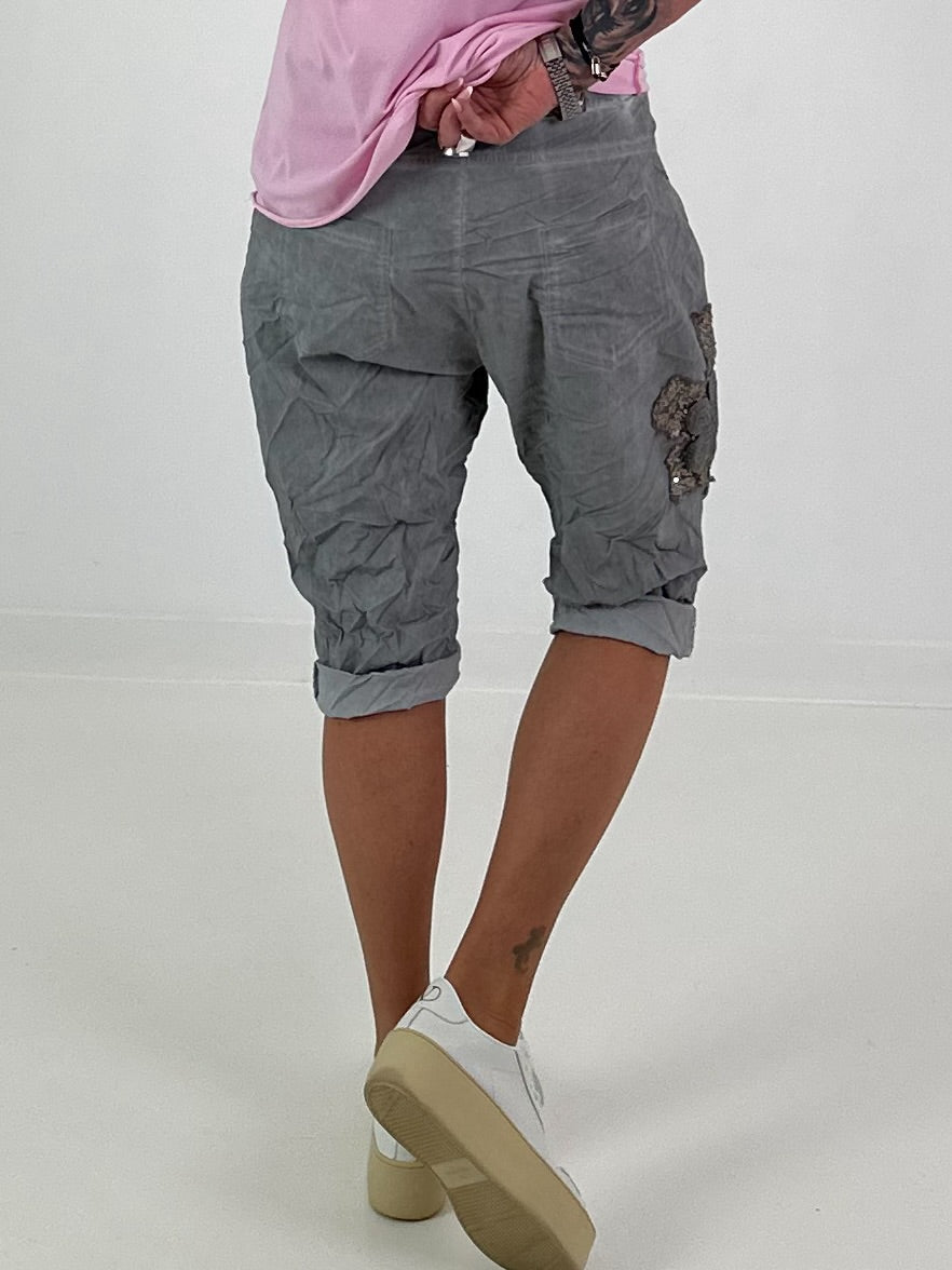 Kurze Baggy mit Häkelblumen und Pailletten - grau