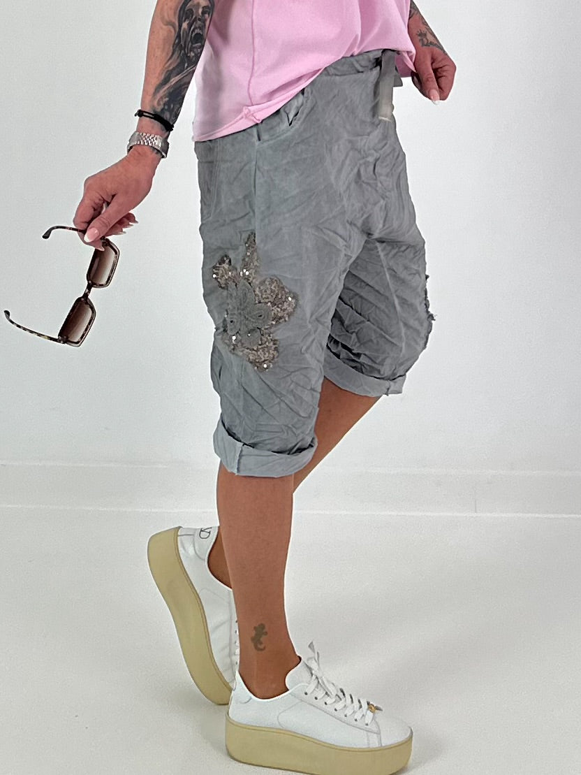 Kurze Baggy mit Häkelblumen und Pailletten - grau