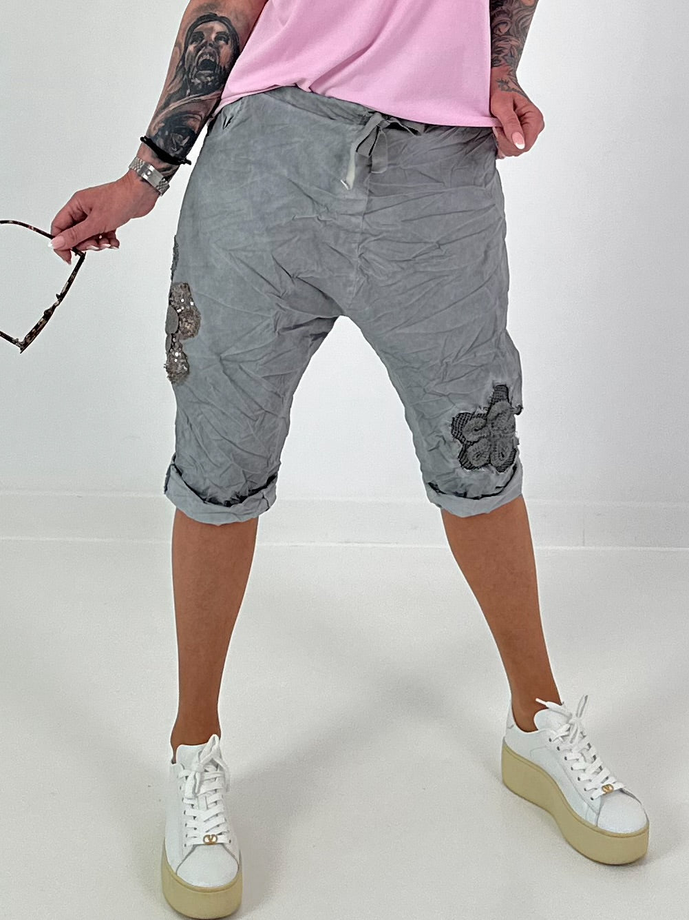 Kurze Baggy mit Häkelblumen und Pailletten - grau
