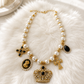 Statement Kette mit Zierperlen und Krone - weiss-gold-schwarz